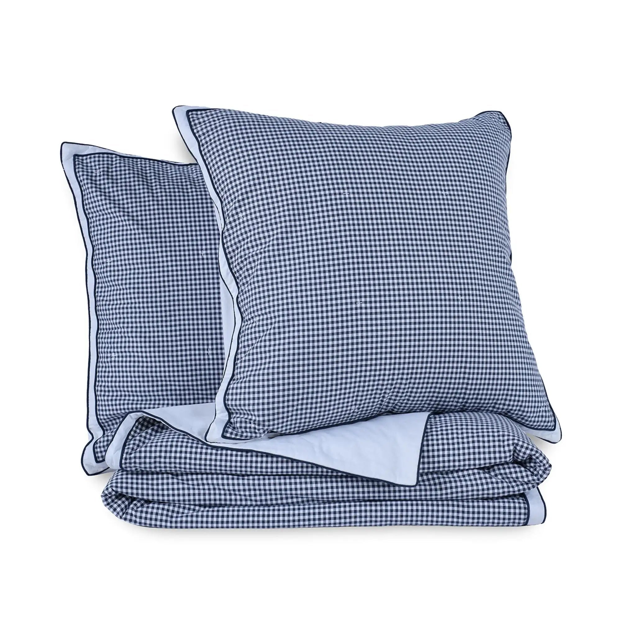 A folded quilt featuring a navy and white gingham checkered pattern, including two euros.