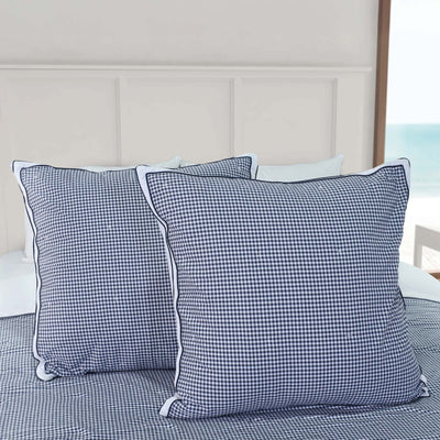 Two blue checkered euro shams on a bed.