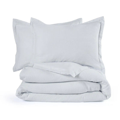 A folded comforter set consisting of a gray textured comforter and two matching pillow shams, on a seamless white background.