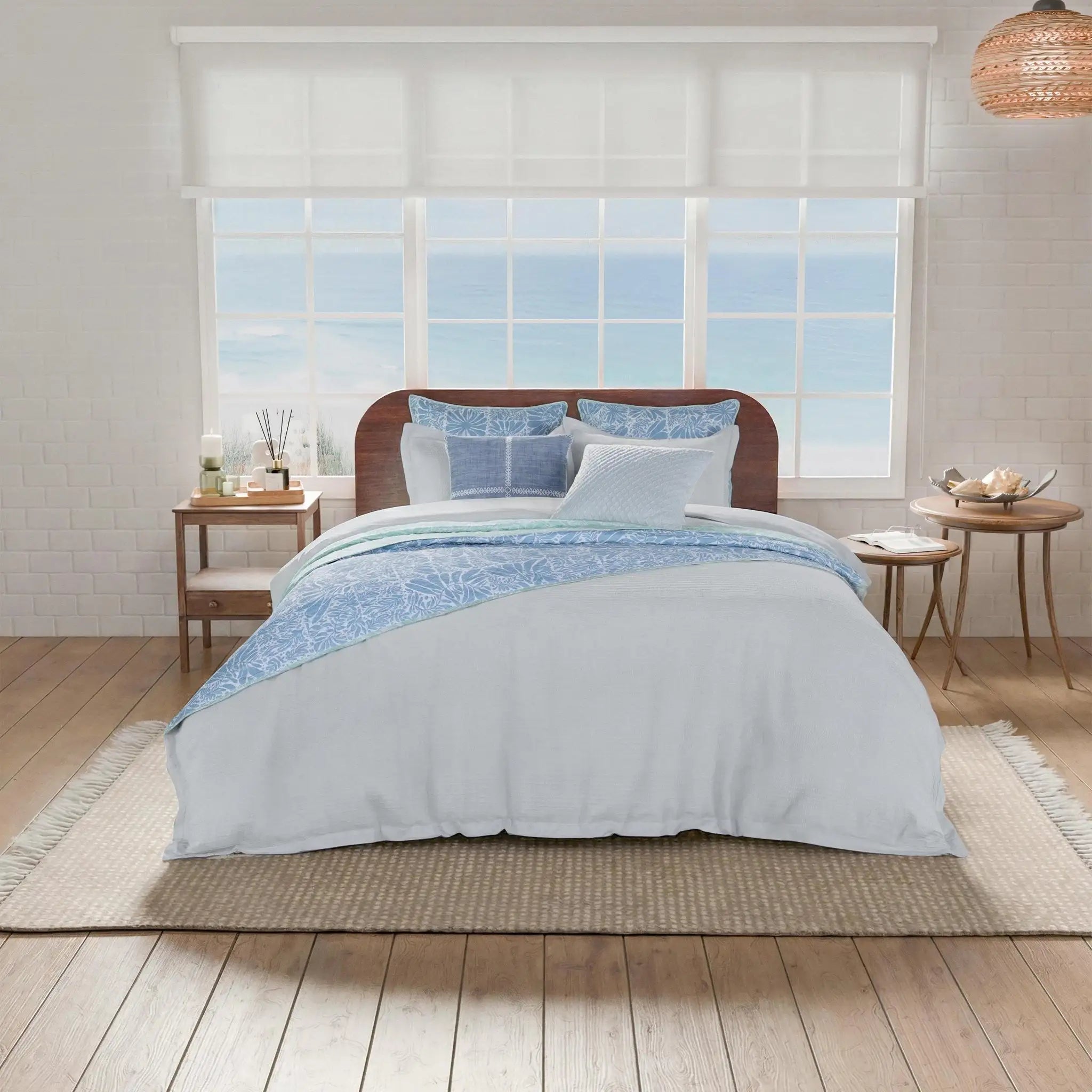 Bedroom with a bed covered in light blue bedding and pillows.