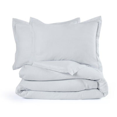 Light gray comforter set with two on a white background