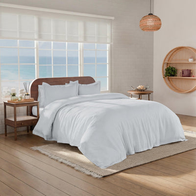 Bedroom scene with a neatly made bed showcasing a grey comforter set.