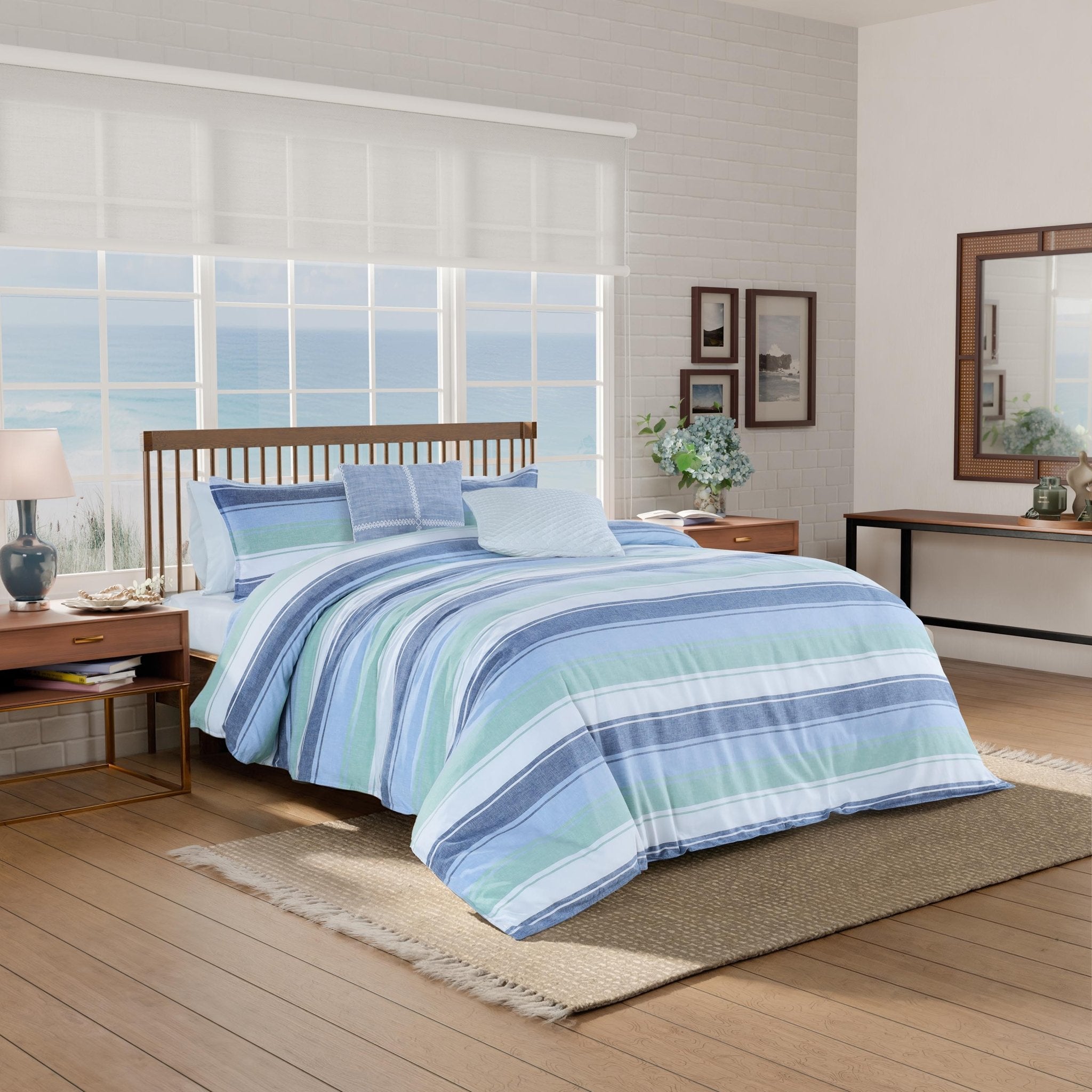 Bedroom with striped comforter and shams on a bed.