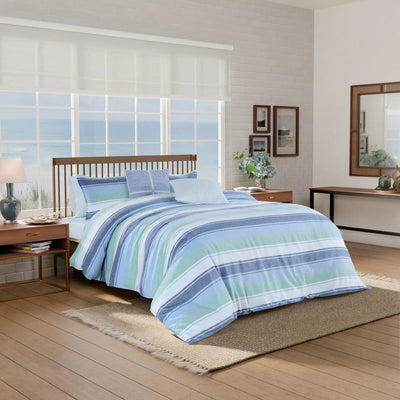 Bedroom with striped bedding on a bed, wooden nightstands, and a large window.