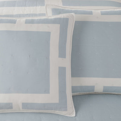 Ivory and blue patterned euro sham on a matching fabric background