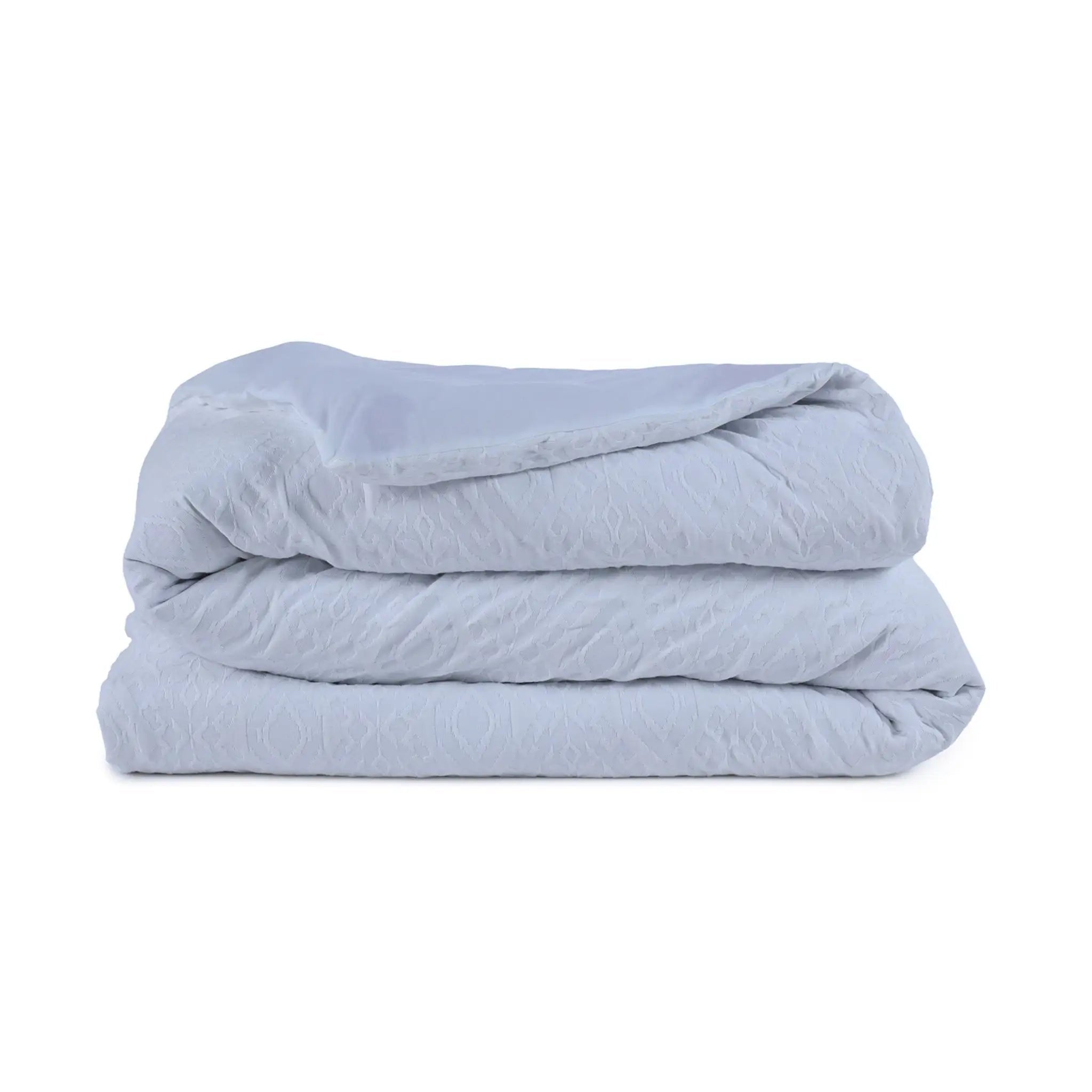 Folded white comforter on a white background