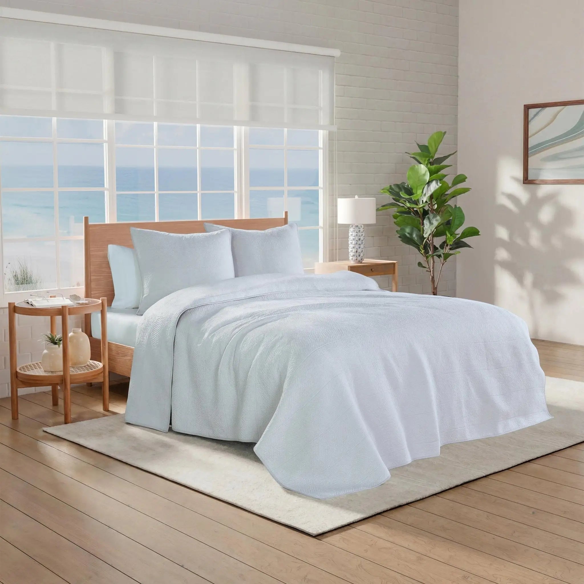 Neatly made bed with gray quilt and euros.
