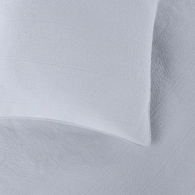 Close up of gray quilt and euro on top of it