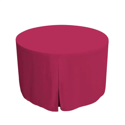 Round table covered with a fuchsia colored tablecloth on a white background