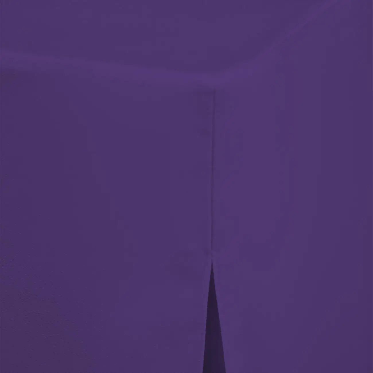A close-up of a solid violet fabric surface with a visible fold or crease running vertically near the center.
