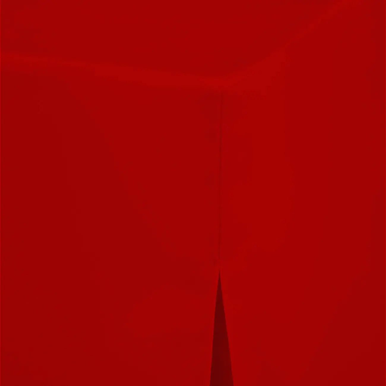 A close-up of a solid deep red table cover with a subtle vertical seam and a small pointed fold near the bottom center.