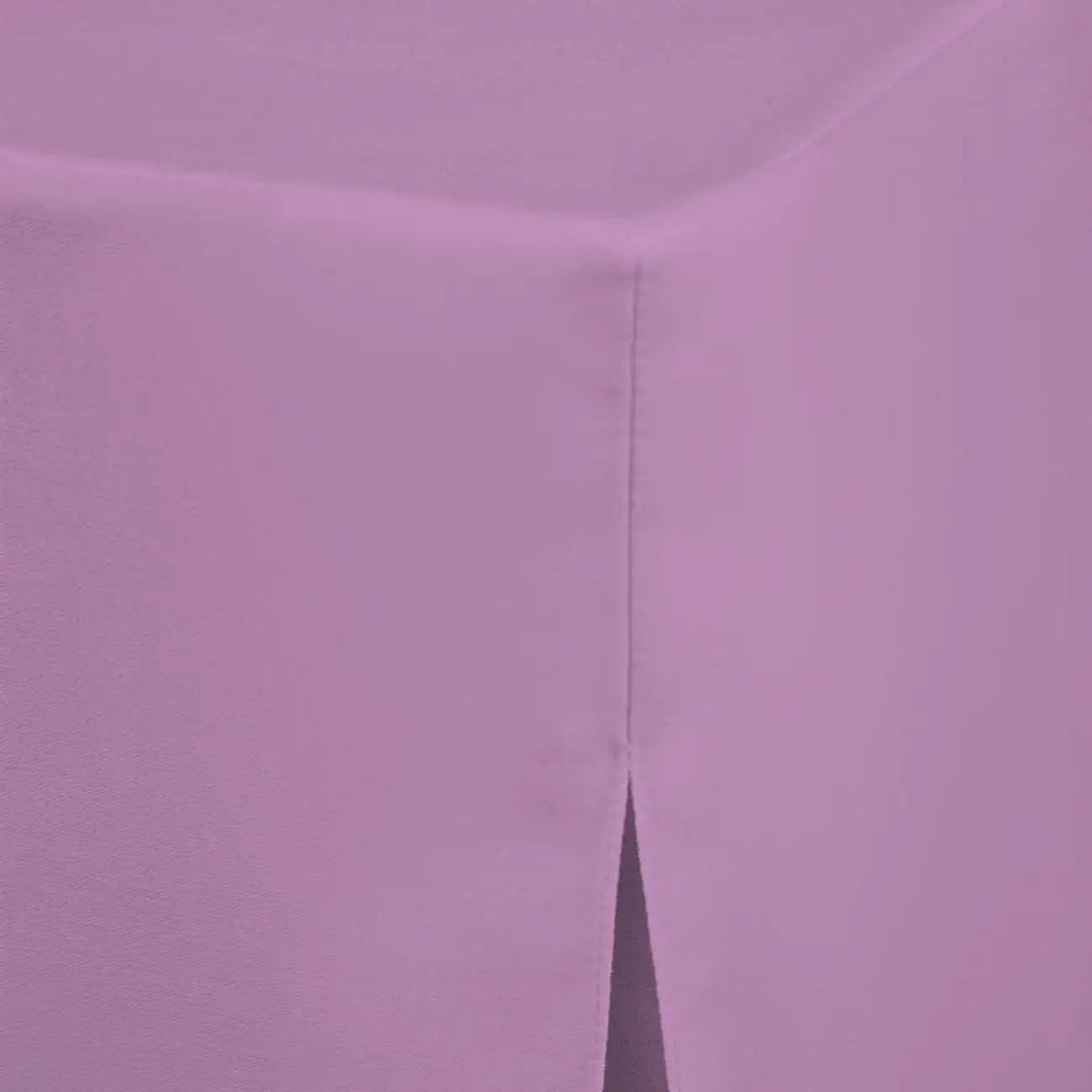 A close-up of a lavender lilac fitted table cover with a visible corner and a vertical pleat seam.