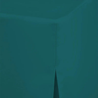 A close-up of a solid teal fabric surface showing a corner fold and a narrow vertical seam.