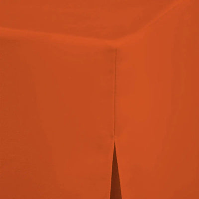 A close-up of a solid orange textured table cloth, showing a vertical seam and a pointed corner.
