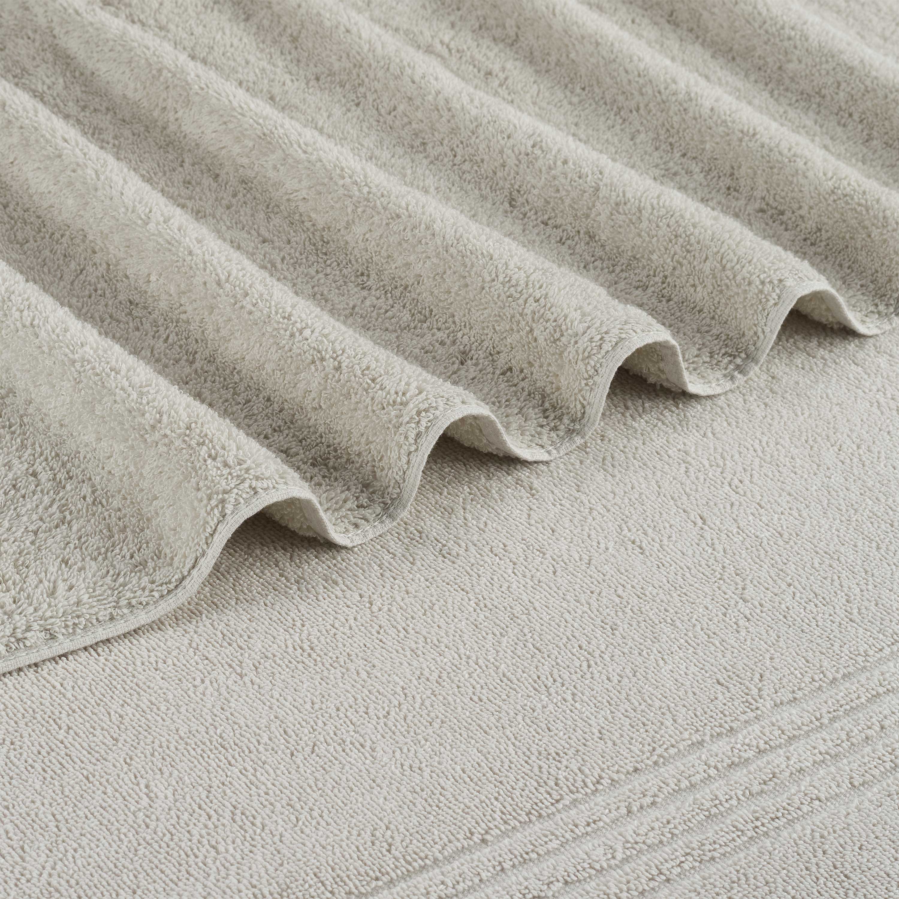 Oversized bath towel with a soft, textured surface, featuring folded edges in a neutral color.