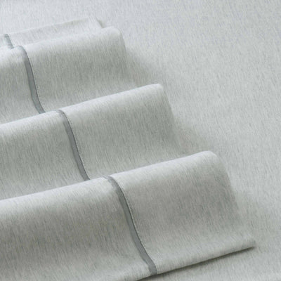 Light gray herringbone patterned sheets with a smooth texture and contrasting trim.
