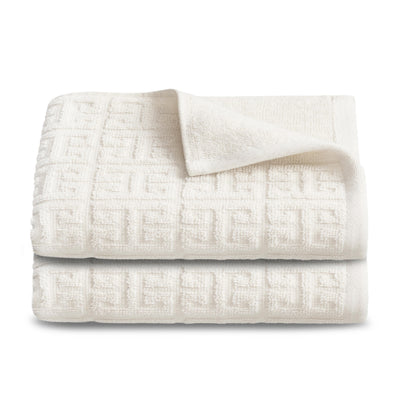 Two stacked hand towels in a textured white fabric with a geometric pattern.