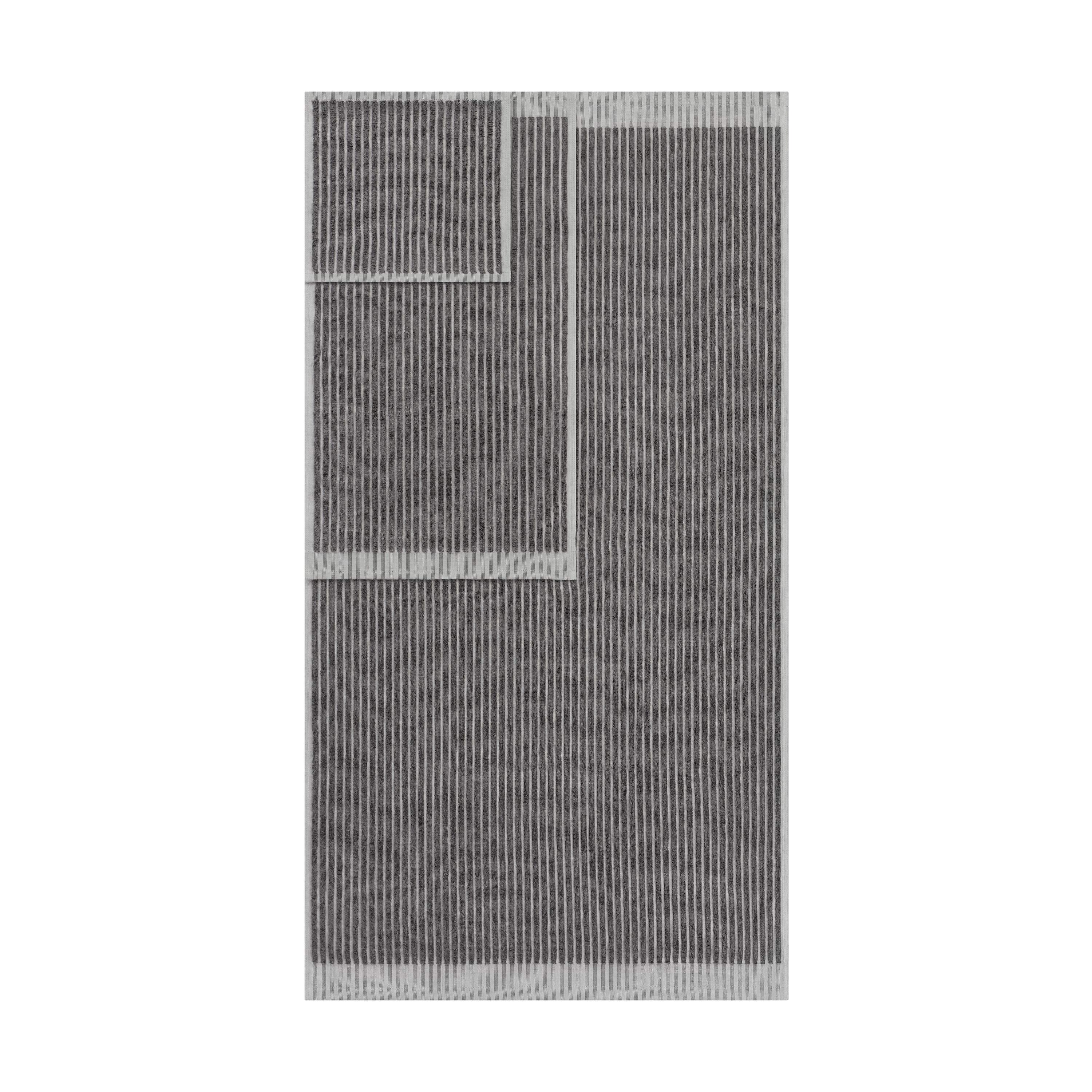 Two towels in gray with a sculpted stripe design, one large and one small, displayed together.