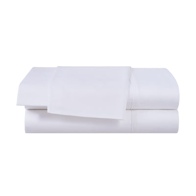 Solid white cotton and Tencel sheet set neatly stacked with a flat sheet on top and fitted sheet underneath.