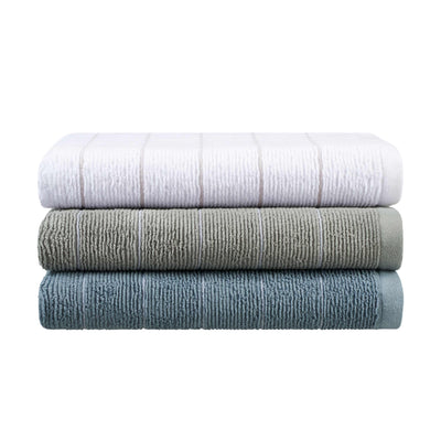 Three stacked towels in white, gray, and teal with a textured slub stripe design.