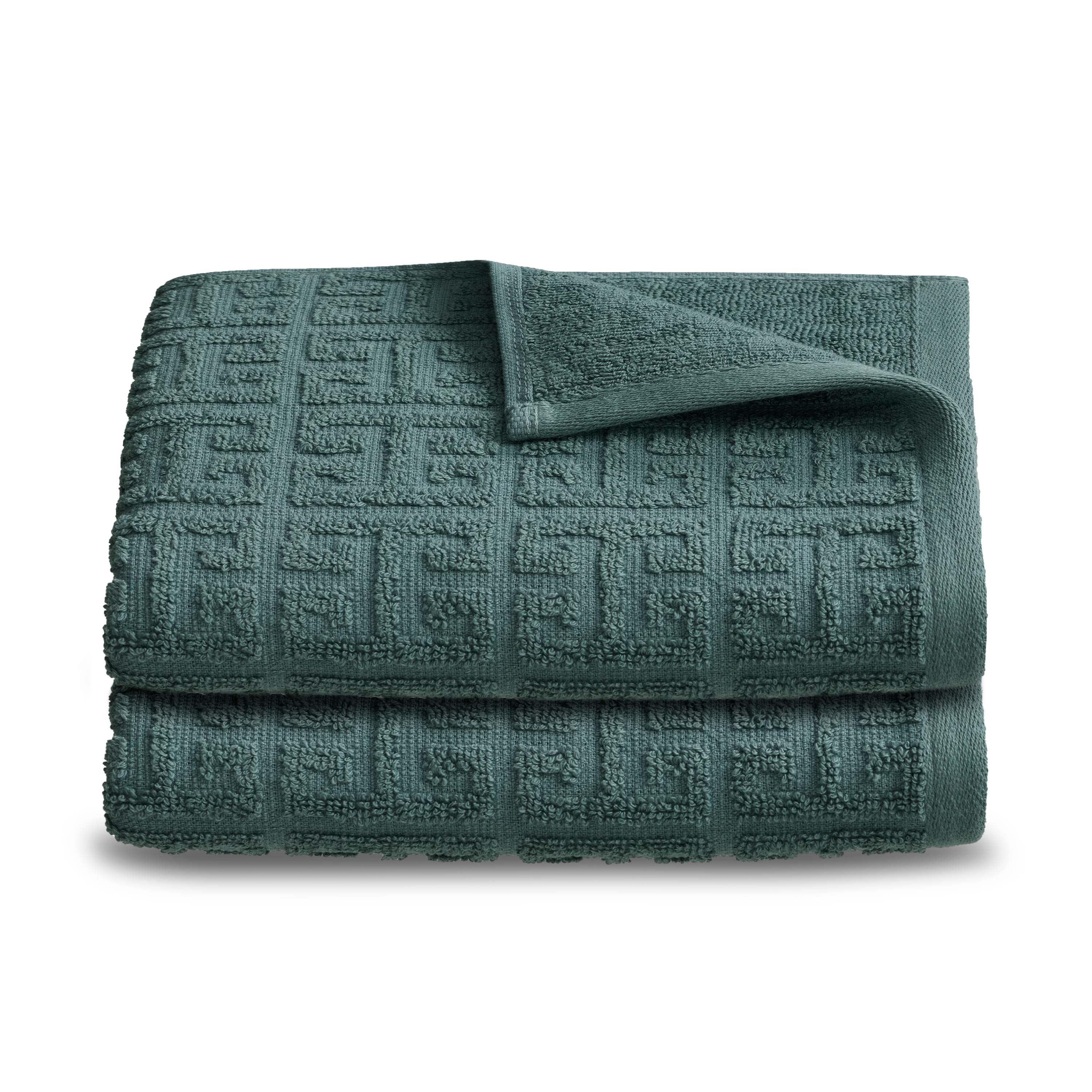 Two folded hand towels in a textured, dark green fabric with a geometric pattern.