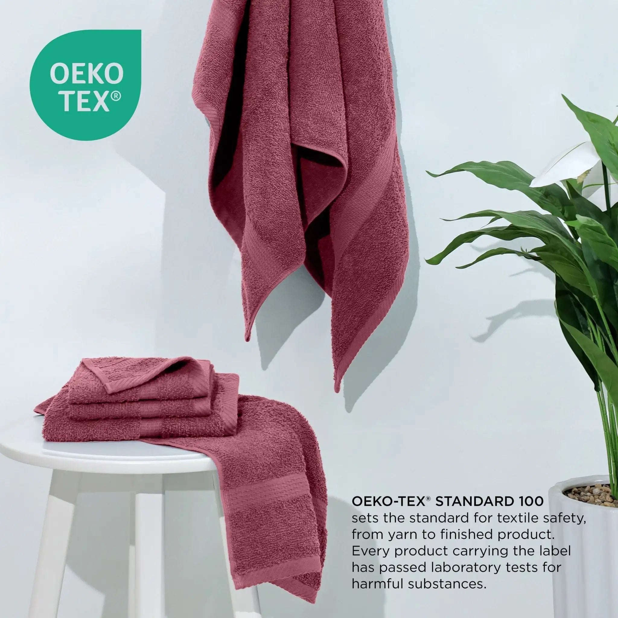 Soft Red towels on a white stool with a plant, featuring the Oeko-Tex logo.