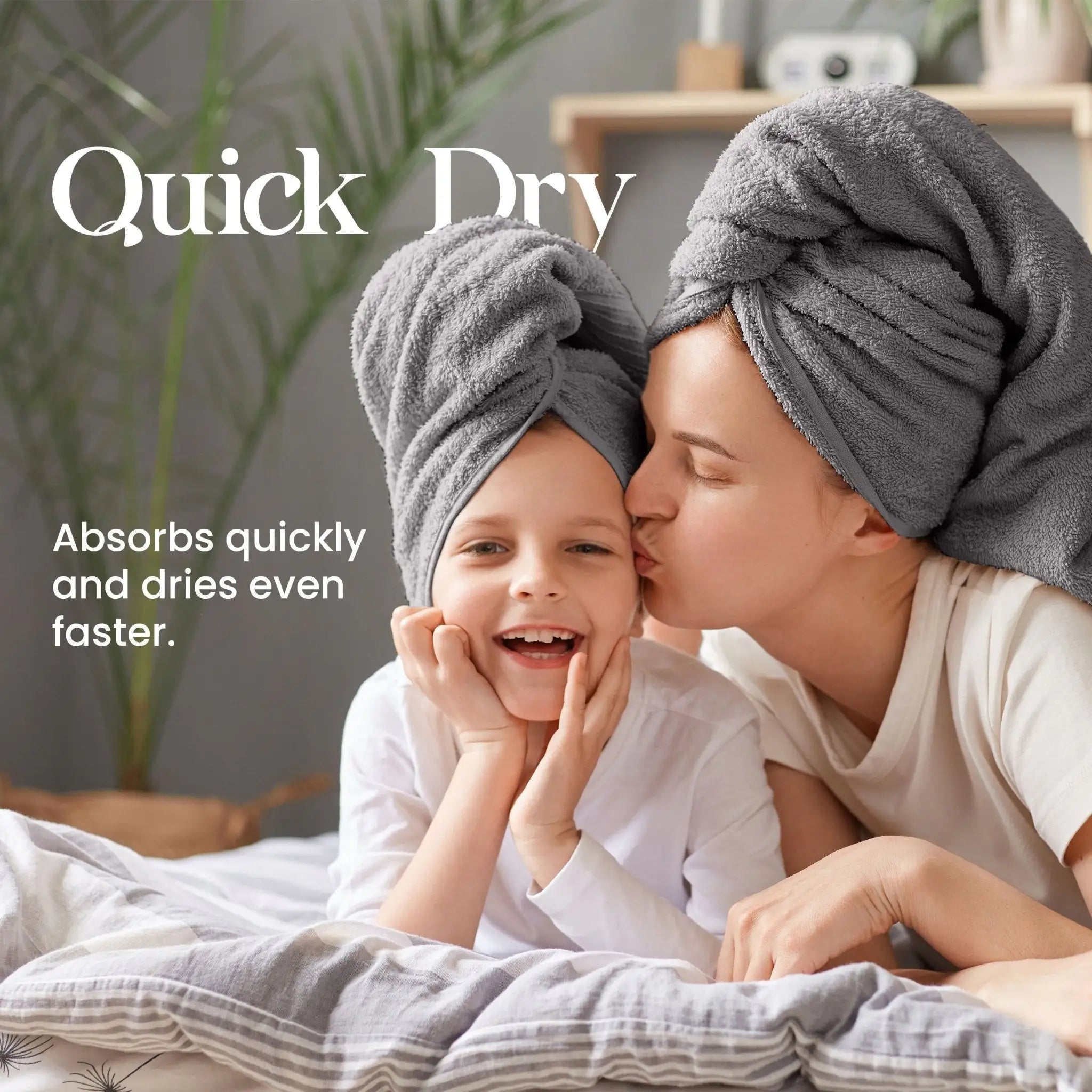Mother and child with gray towels on heads, lying on a bed with text 'Quick Dry' and product description.