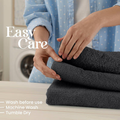 Person folding black towels with washing machine in the background, text indicating care instructions.