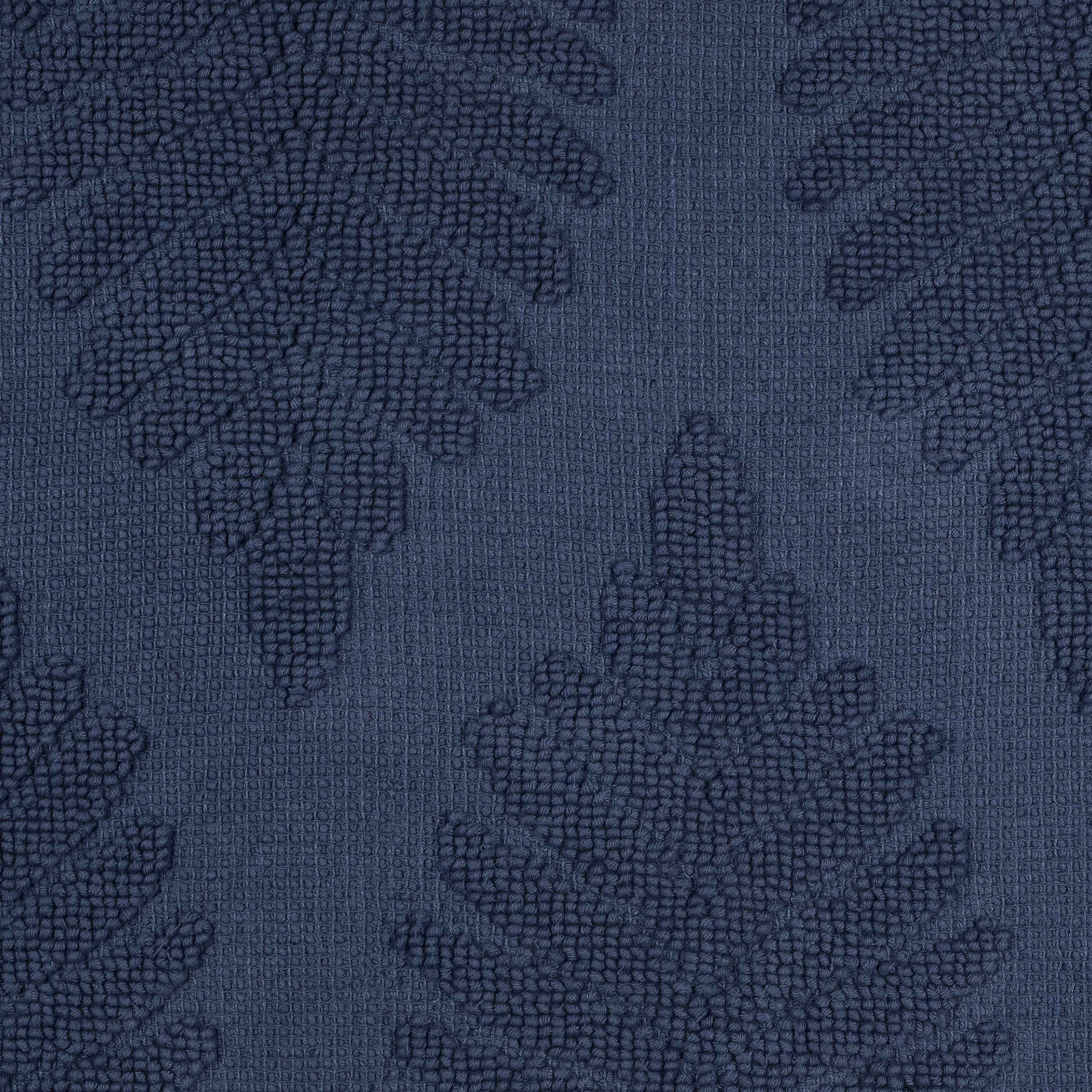 Dark blue bath rug featuring a textured fern ogee pattern.