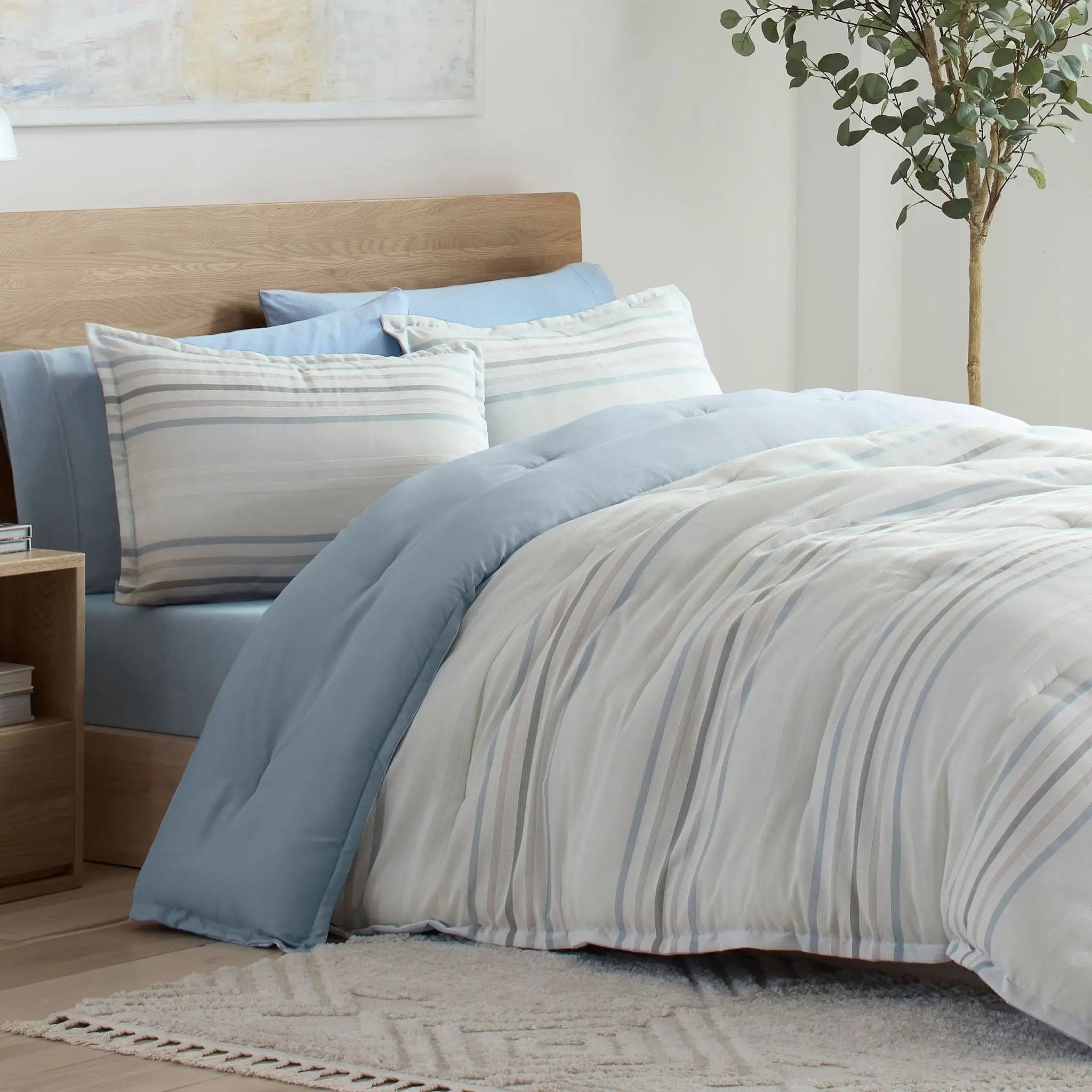 Bed with striped bedding and pillow shams in a bedroom setting