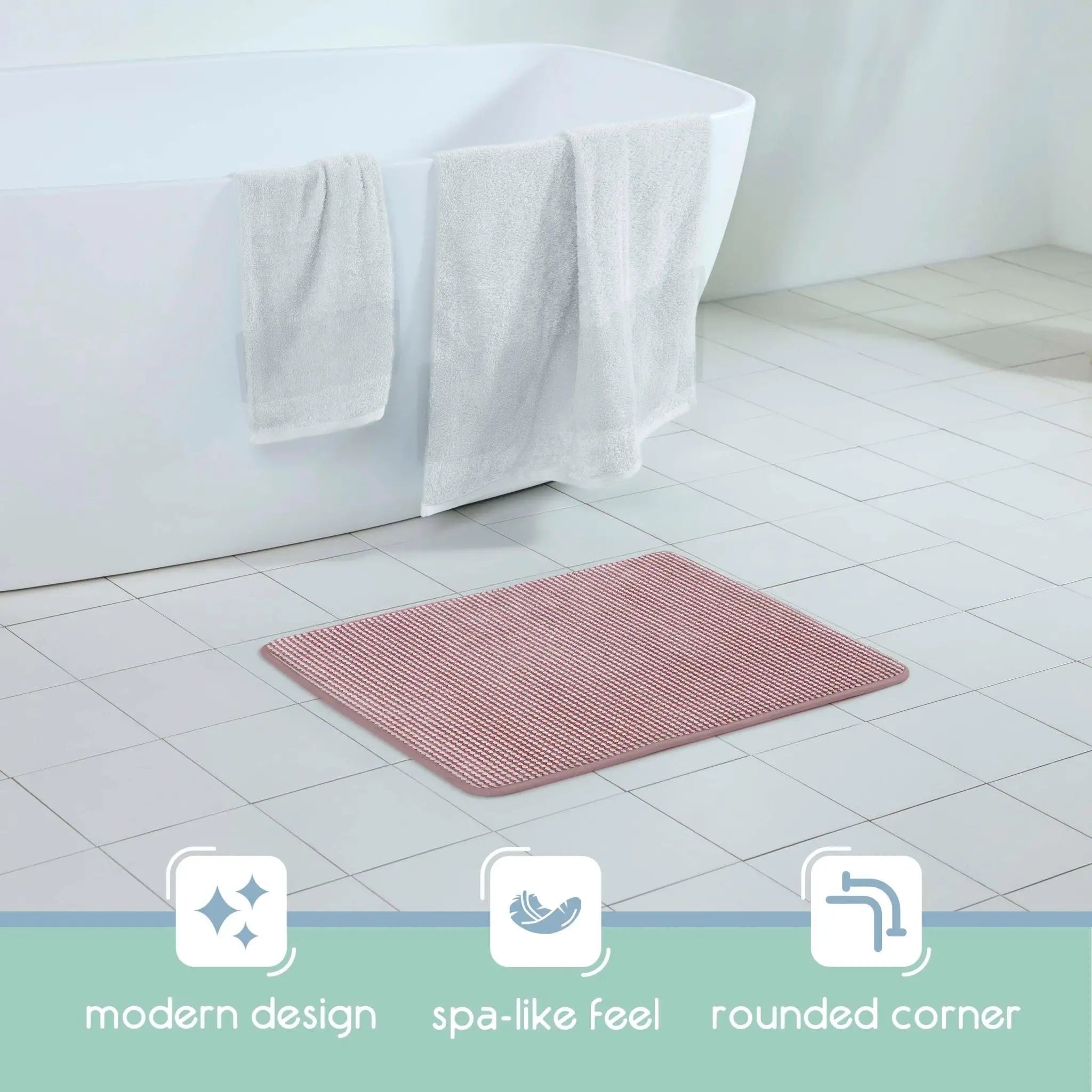 A berry bath rug with rounded corners placed on a white tiled bathroom floor in front of a white bathtub with white towels draped over the edge. Three feature icons and the text 'modern design', 'spa-like feel', and 'rounded corner' appear along the bottom.