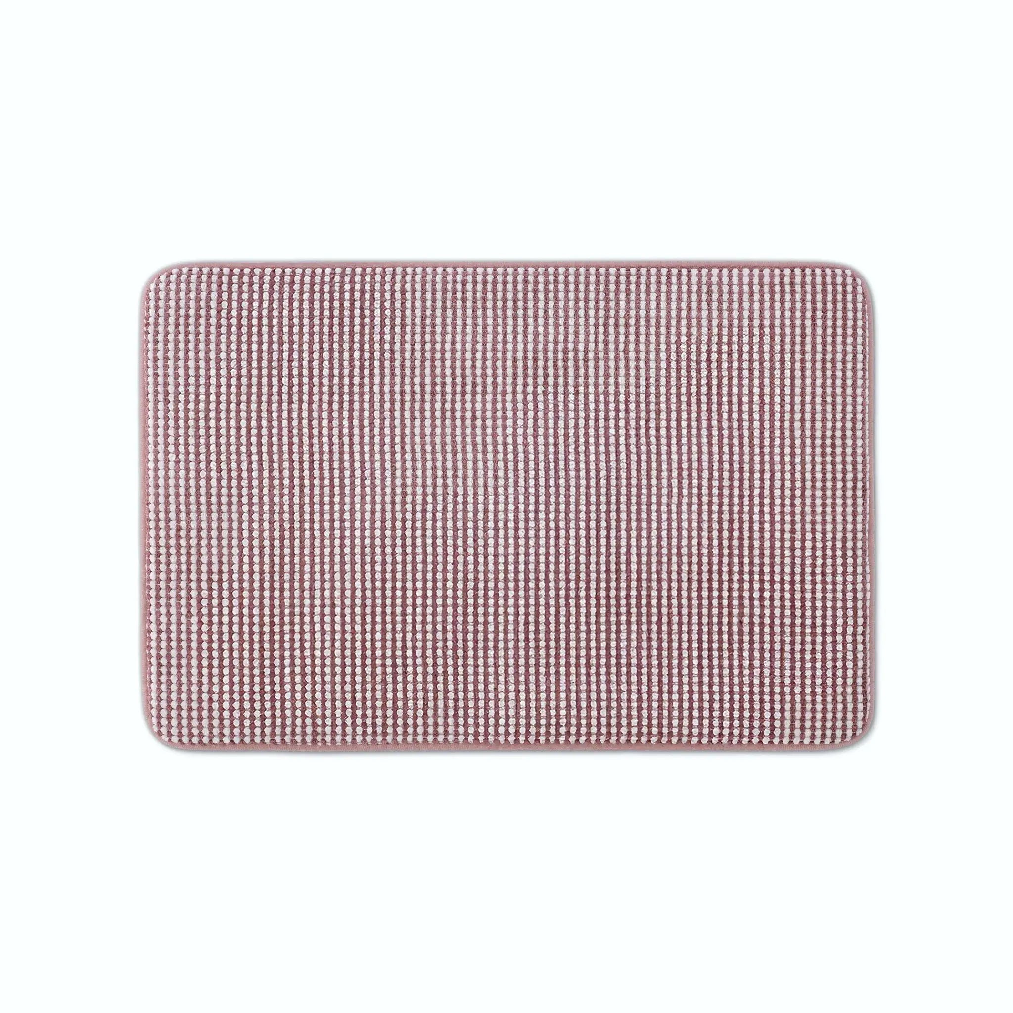 A rectangular berry color bath rug with rounded corners.
