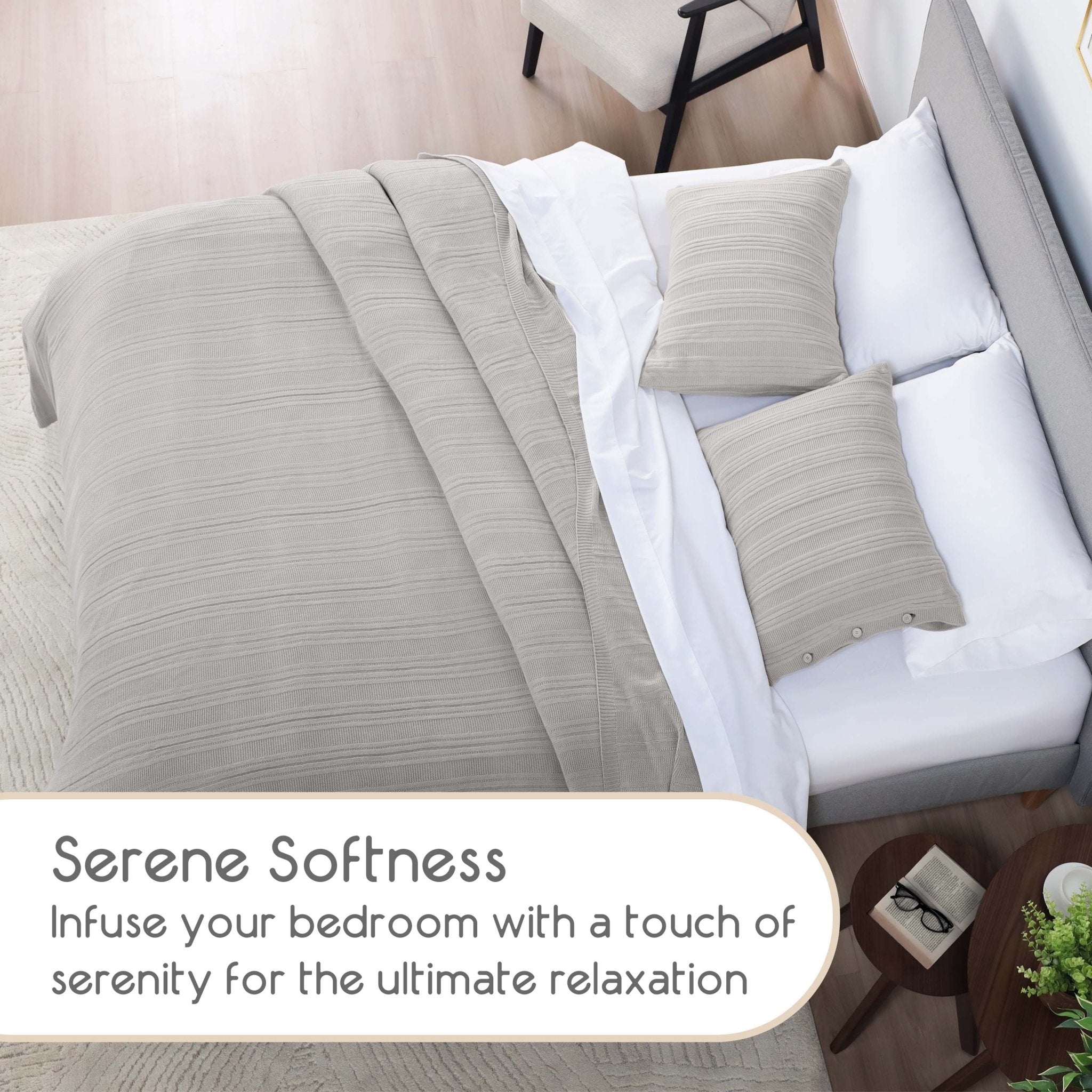 Neatly made bed with gray blanket and pillows in a bedroom setting.