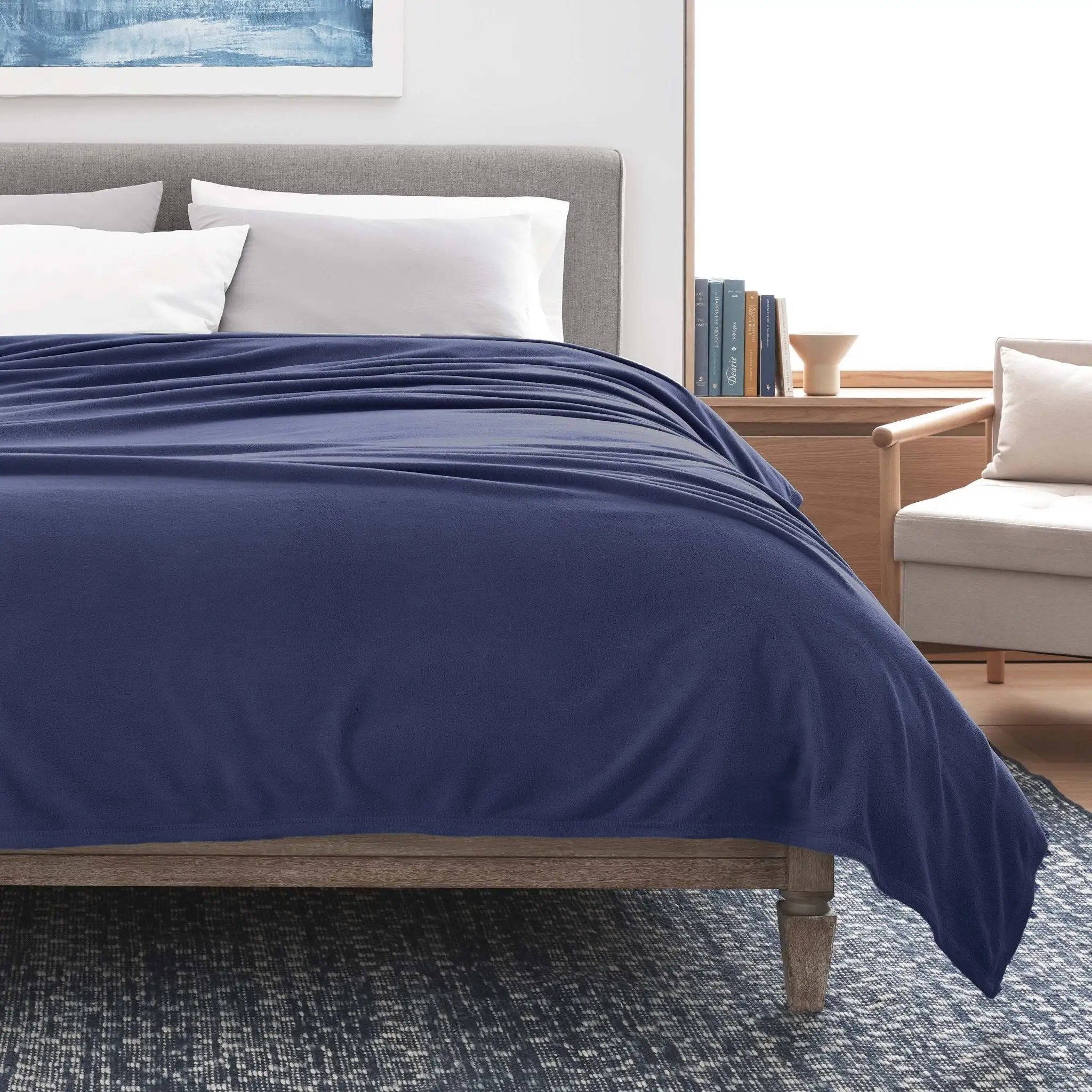 Bed with navy blanket in a bedroom setting