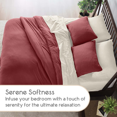 Bed with red and white comforter and pillow shams in a room setting.