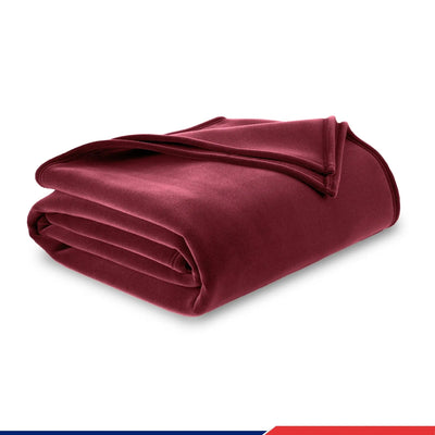 A folded plush velvet blanket in a deep burgundy color, presented on a clean white background with a subtle drop shadow.