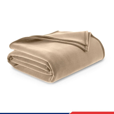 Folded beige blanket on a white background