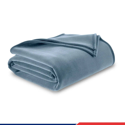 A folded blue fleece blanket on a white background.
