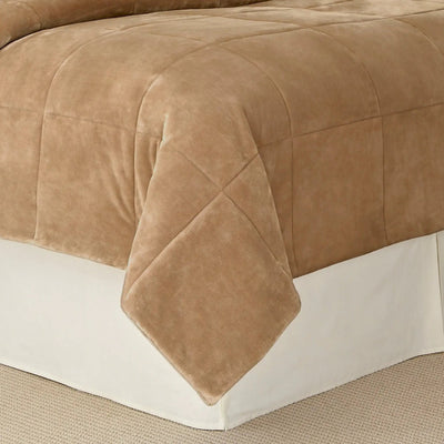 Sand blanket on a bed with a white baseboard