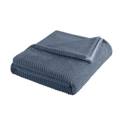 Folded blue textured blanket on a white background