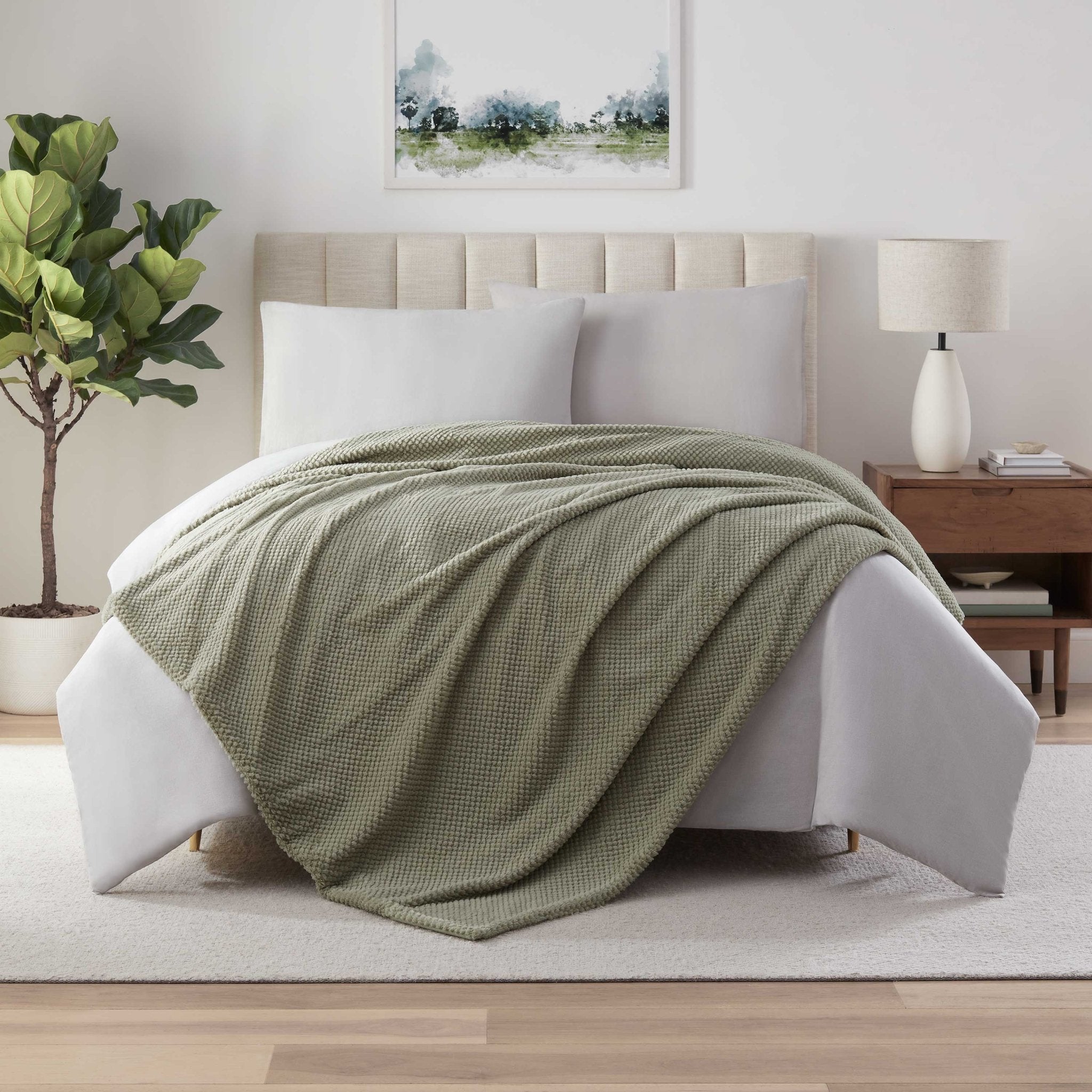 Green blanket on a bed in a bedroom 