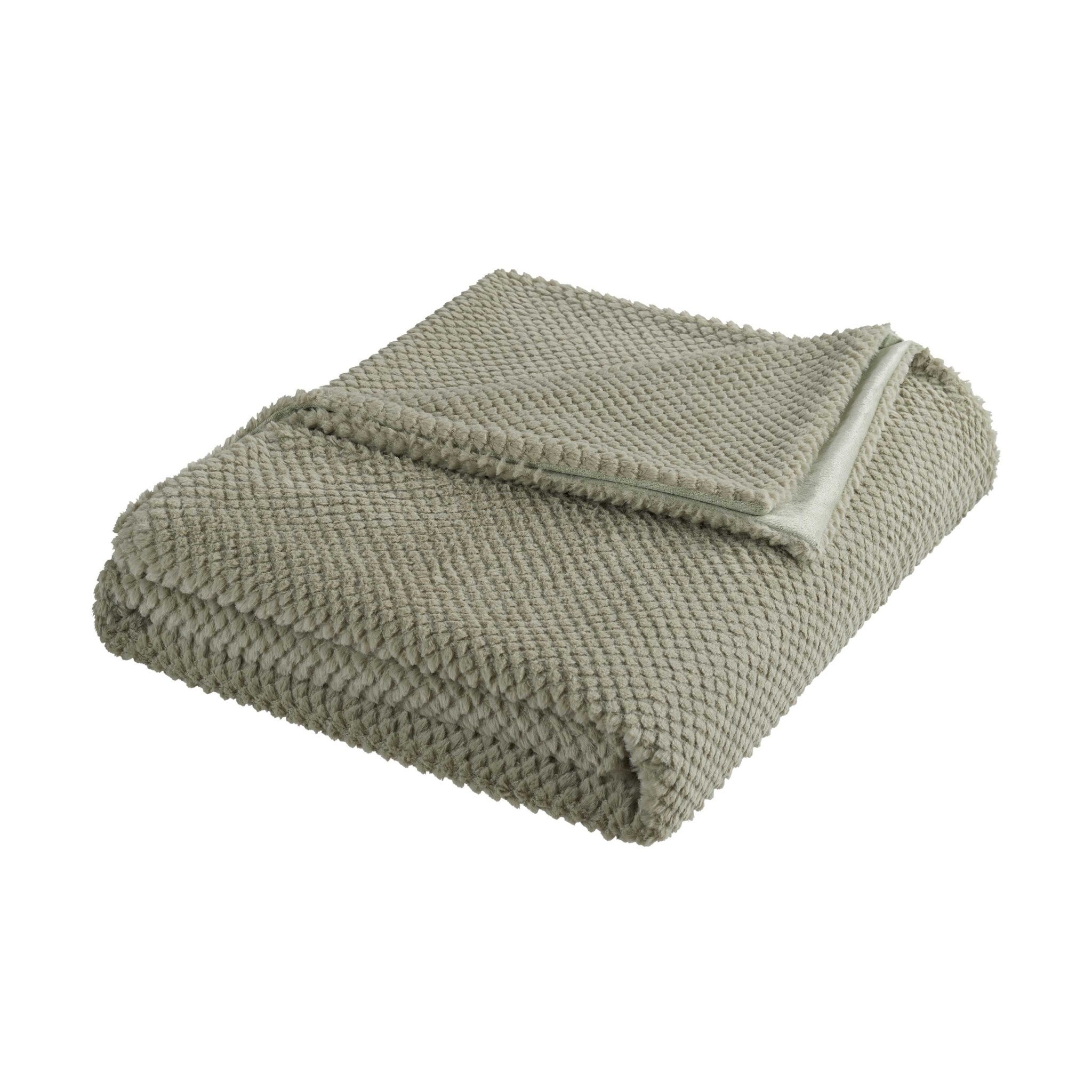 Folded green blanket on a white background