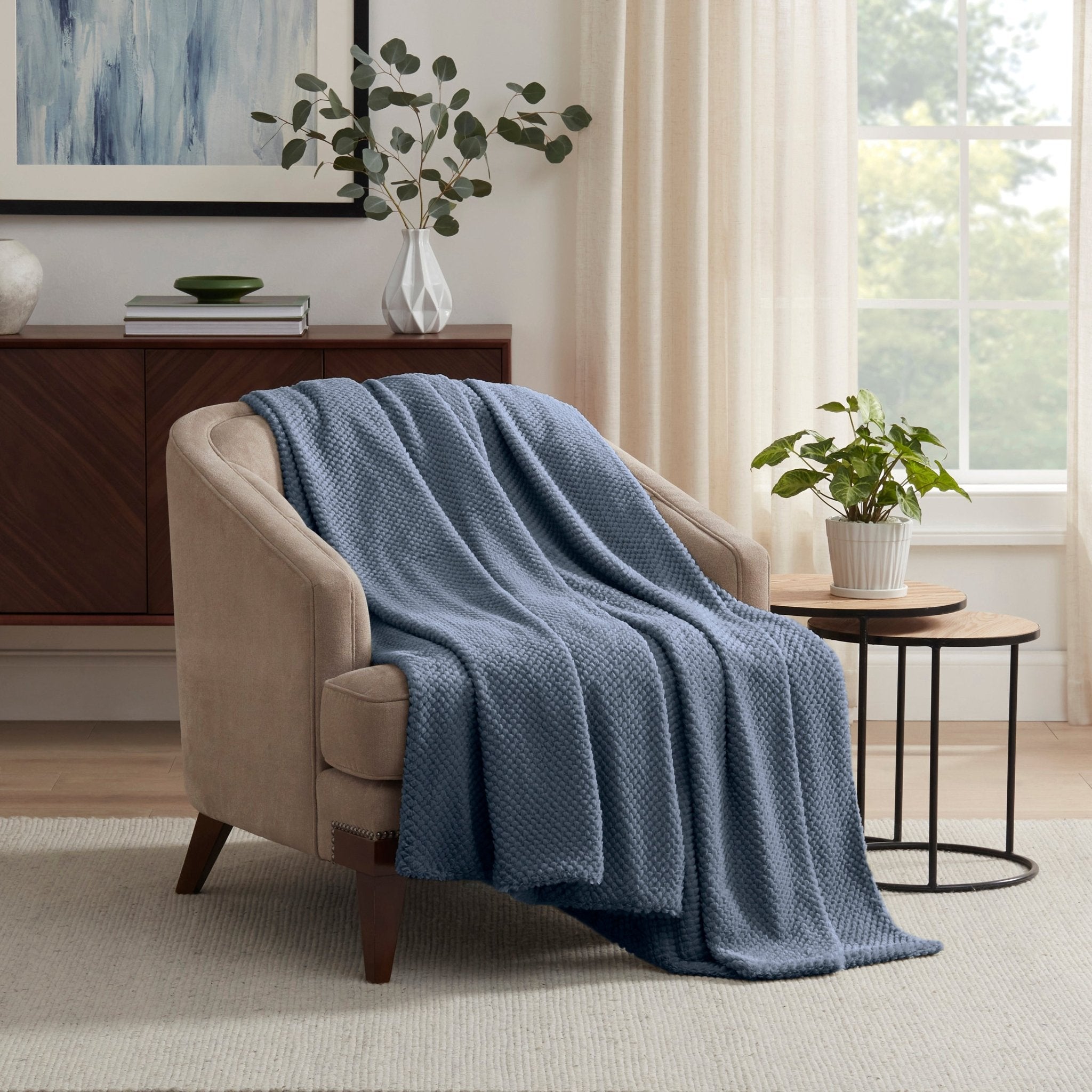 Blue blanket draped over a beige armchair in a living room 