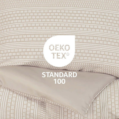 Close-up of a beige comforter set with a white Oeko-TEX Standard 100 certification label overlaid in the center.