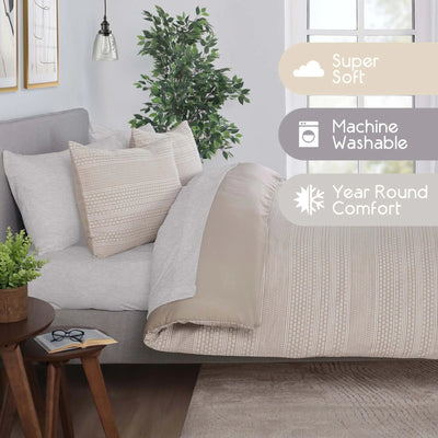 A styled bed in a bedroom setting with light beige comforter set. The scene includes three informational text overlays on the right side reading 'Super Soft', 'Machine Washable', and 'Year Round Comfort'.