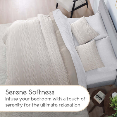 Neatly made bed with textured bedding and pillows in a bedroom setting.