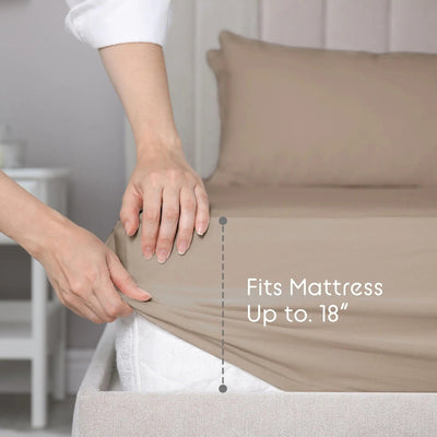 Person adjusting a beige fitted sheet on a bed with text indicating mattress size compatibility.