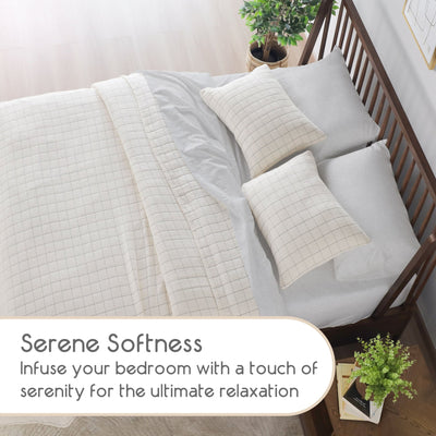 Bed with Ivory coverlet set in a bedroom setting, featuring text about serene softness.