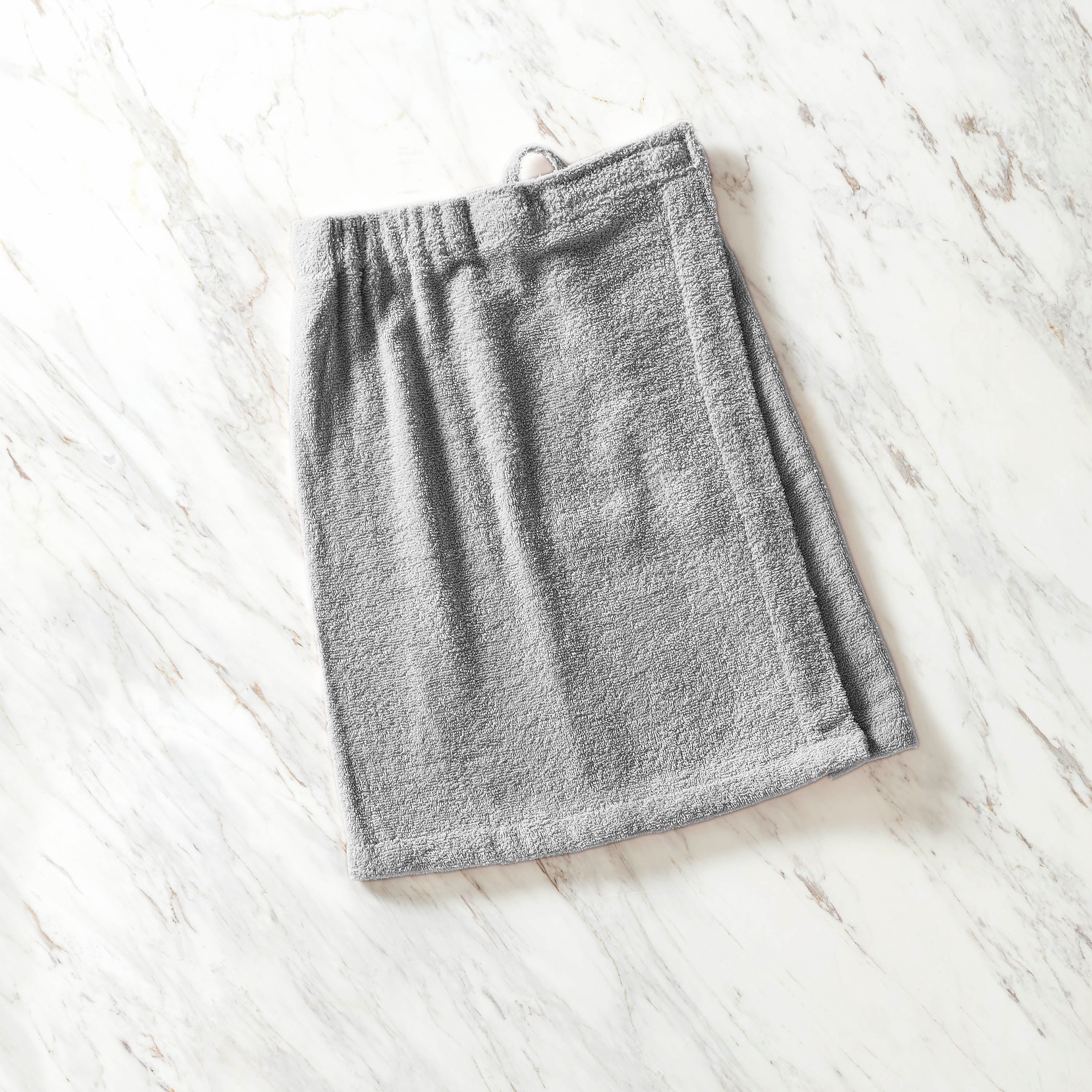 Gray youth shower wrap with an elastic waistband, laid flat on a marble surface.