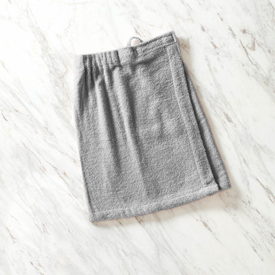 Gray youth shower wrap with an elastic waistband, laid flat on a marble surface.